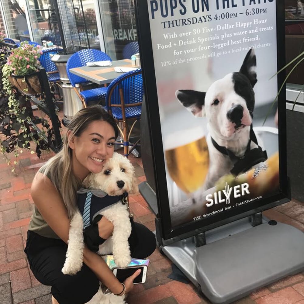 Irena smiling with a small dog at a pet-friendly patio